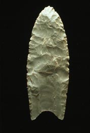 "A Clovis blade with medium to large lanceolate spear-knife points. Side is parallel to convex and exhibit careful pressure flaking along the blade edge. The broadest area is near the midsection or toward the base. The Base is distinctly concave with a characteristic flute or channel flake removed from one or, more commonly, both surfaces of the blade. The lower edges of the blade and base is ground to dull edges for hafting. Clovis points also tend to be thicker than the typically thin later stage Folsom points. Length: 4–20 cm/1.5–8 in. Width: 2.5–5 cm/1–2