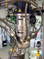 A low pressure mix head with calibration chamber installed, showing material supply and air actuator lines.