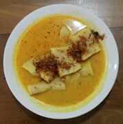 Laksan Palembang, fish cake similar to pempek served in rich coconut milk-based soup, and sprinkled with crispy fried shallot.