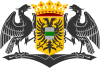 Two black eagles holding a crowned yellow shield