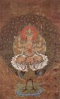 A portrait-oriented painting depicting a six-armed figure with a red halo sitting inside of a white lotus flower. The flower is resting on the back of a peacock, whose tail feathers are fully extended.