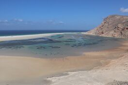 A sandy beach framed by rocky cliffs