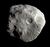 A partially-illuminated irregular body, which has a shape remotely resembling a cube. The body's surface consists of ridges and valleys and is covered by craters.