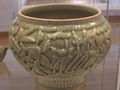 A celadon shoulder pot from the late Yuan Dynasty, displaying artwork of peaches, lotuses, peonies, willows, and palms.