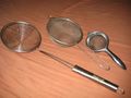 Several wire meshes shaped like bowls, with metal handles.