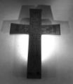 A wooden cross with Arabic calligraphy in Square Kufi style.