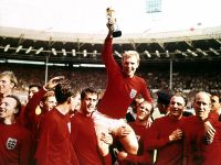 A group of men, holding up a trophy.