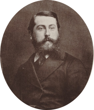 Middle aged white man with short, dark hair and a bushy beard