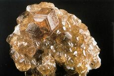 A cluster of orange to red almandine garnet crystals.