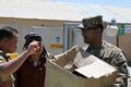 U.S. Army Capt. Syed Ali, right, with a regional communications center with Combined Joint Task Force (CJTF) 101, 101st Airborne Division, with prepares to distribute school items to Afghan children at the El 130827-A-YW808-001.jpg