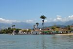 Plain with old buildings, forests, moutains and palm trees.