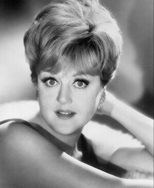 A young white woman, with bare arms, looking directly at the viewer.
