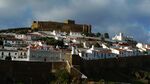 Castle above a town, houses with white facades