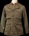 An olive drab M-1943 field jacket, worn by US soldiers during World War II and the Korean War.