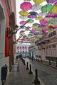 Calle de la Fortaleza leading to the palace with a canopy of multicolored umbrellas
