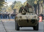 أفراد من الجيش التونسي على مدرعة يلقون بقنابل الغاز المسيلة للدموع والرصاص الحي على المتظاهرين.