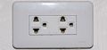 An earthed Thai socket that appears to comply with figure 4 of TIS 166-2549. Although it may accept NEMA plugs, the Thai voltage is 220 V and thus electrically incompatible with US devices.
