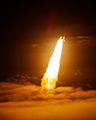 The Space Shuttle Endeavour launches through some clouds.