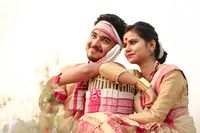 Assamese youth in traditional festive dress. The girl is wearing mekhela sador and bindi on the centre of her forehead.