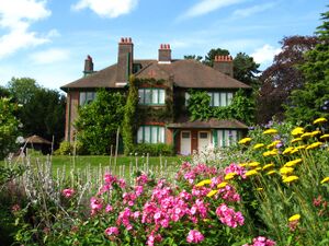 View of modest-sized country house from extensive gardens