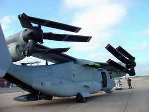 A V-22 with its wing rotated 90 degrees so it runs the length of the fuselage