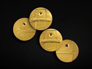 Four gold-coloured medals, two showing obverse, two reverse, dated 2017. The layout of the medal for "Education Development" is mirrored for the "Education research" medal. On the former a person stands looking at a pine tree. On the latter, they sit beneath it.