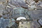 Photo of the "old widow's stone" covered with a wire net