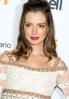 A photograph of Anne Hathaway looking slightly away from the camera.