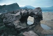 The surface pattern on this pedestal rock is honeycomb weathering, caused by salt crystallisation. This example is at Yehliu, Taiwan.