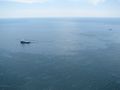 Response boats work to clean up spilled fuel and oil from the rig and undersea wellhead.